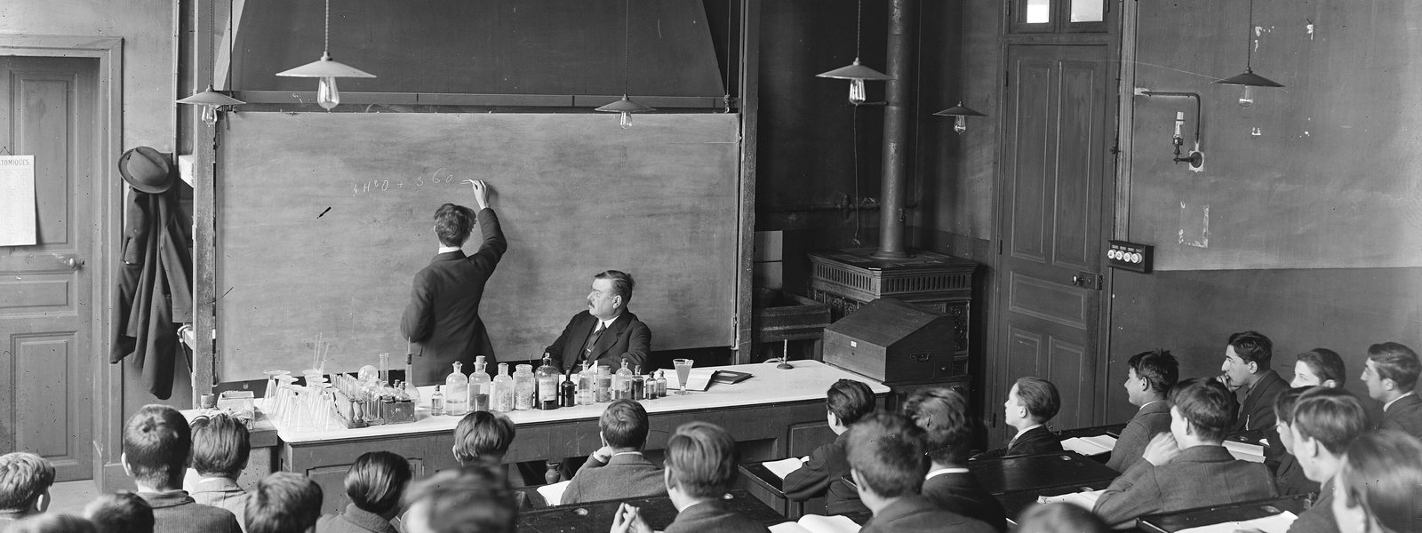 Une salle de classe parisienne en 1921, un élève écrit au tableau devant le professeur