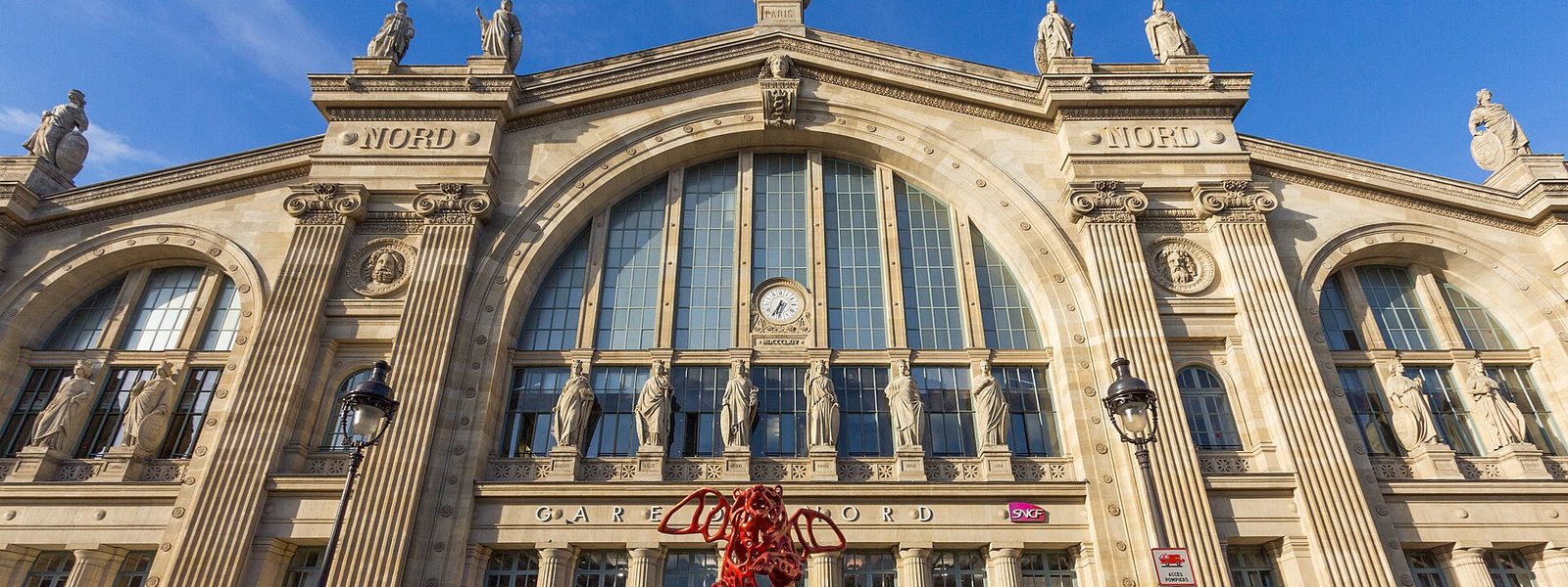 La façade de la gare du Nord à Paris, ses statues de villes et sa grande verrière