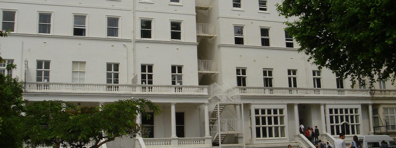 The white stucco front of the Lycée Français Charles de Gaulle on Cromwell Road, with pupils at the entrance