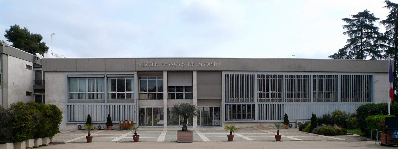 The front of the Lycée Français de Madrid, with its name in capital letters and a French flag